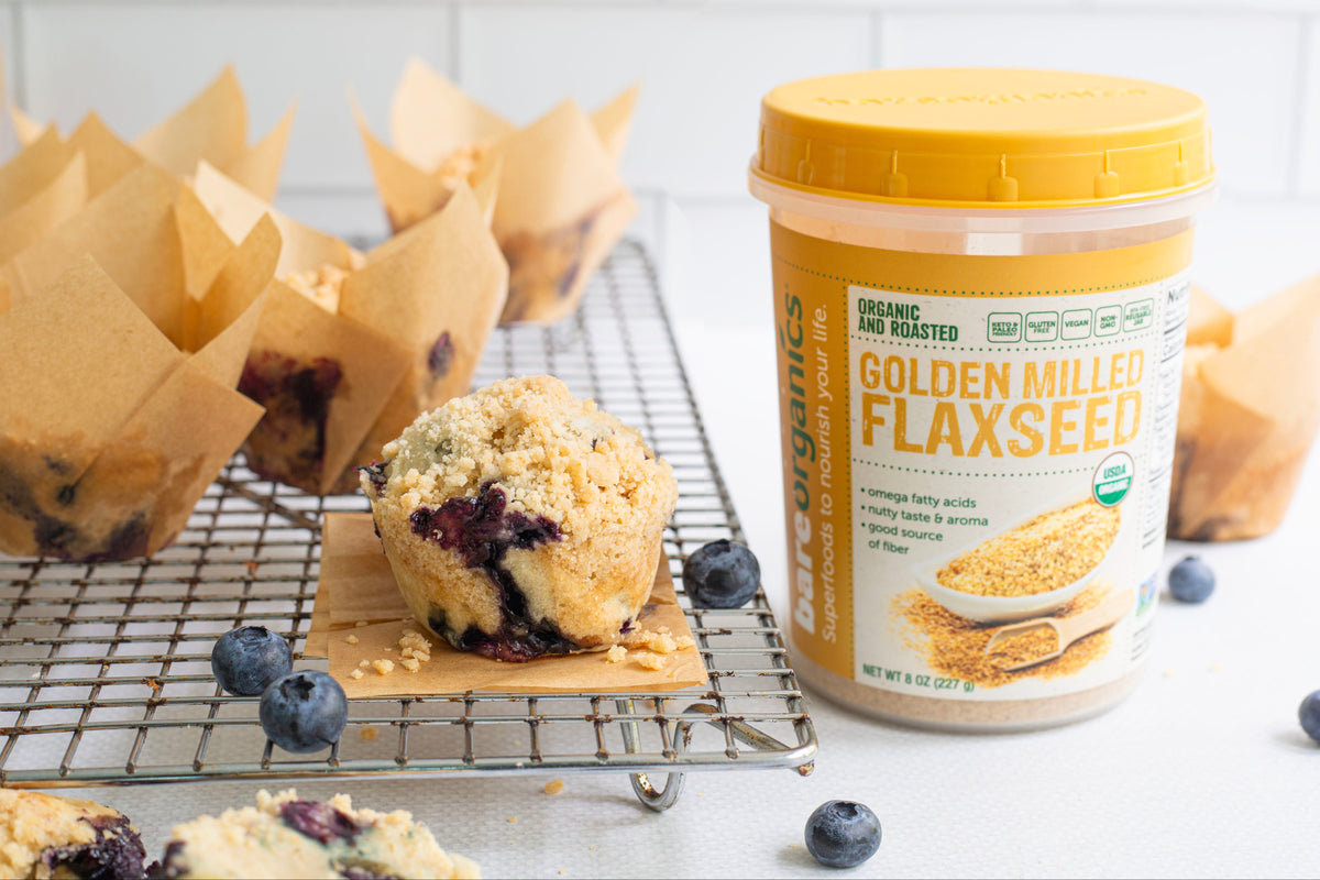 Muffins on a cooling rack with a container of Golden Mills Flaxseed in the background.